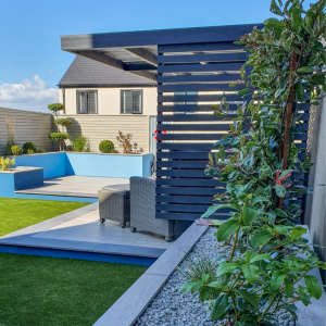 Porcelain paving with outdoor seating and blue painted rendered wall with a Blue pergola